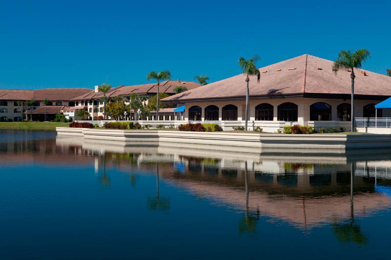 A peaceful tropical resort by the water with palm trees and clear reflections.