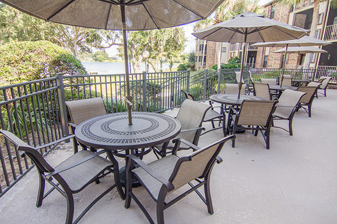 Outdoor patio area with tables, chairs, and umbrellas for relaxation.