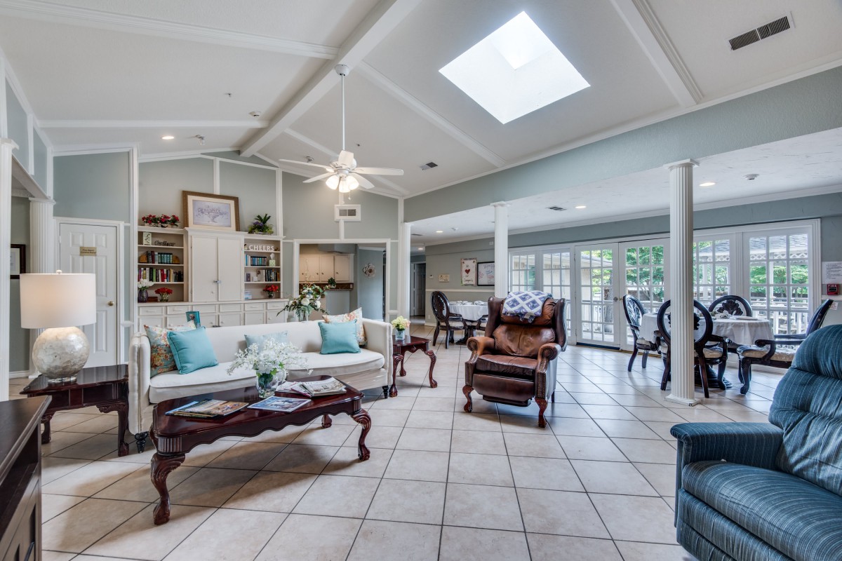 A spacious living room featuring elegant furniture, a skylight, and ample natural light.