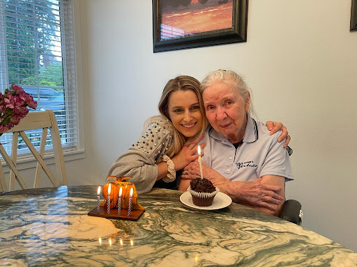 A joyful birthday celebration with loved ones, featuring a cupcake and candles.