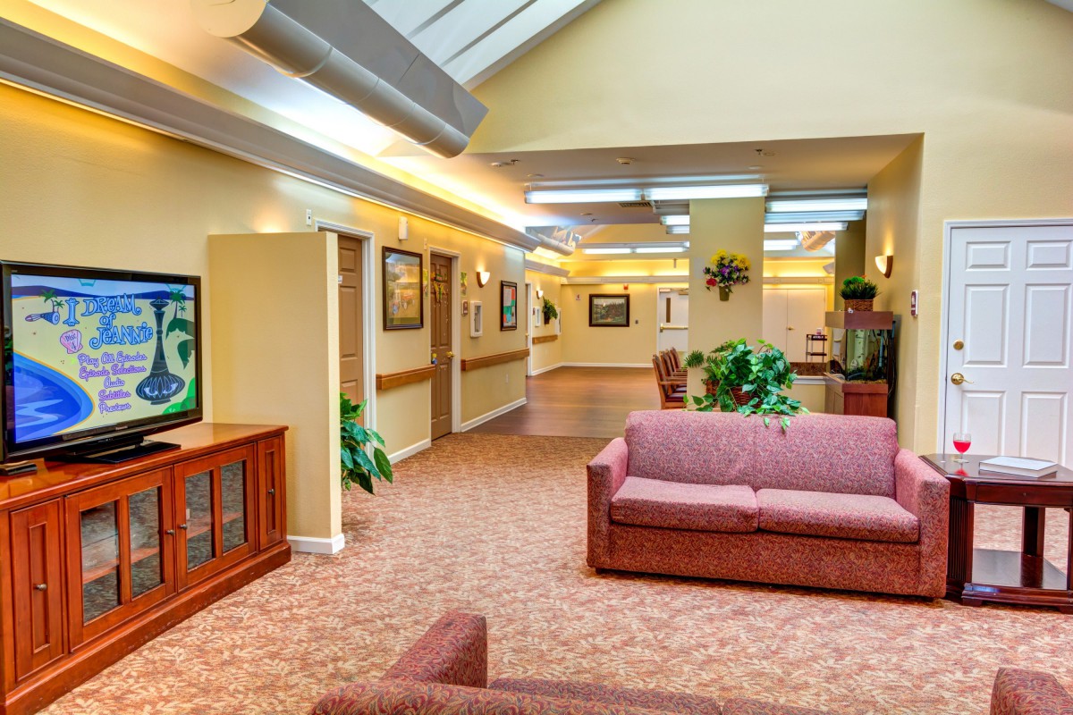 A spacious lobby area with comfortable seating, artwork on the walls, and decorative plants.