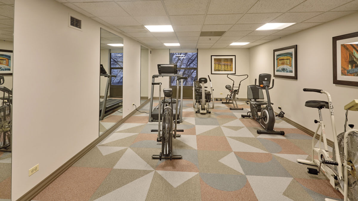 A modern gym with various exercise equipment and mirrors for an indoor workout.