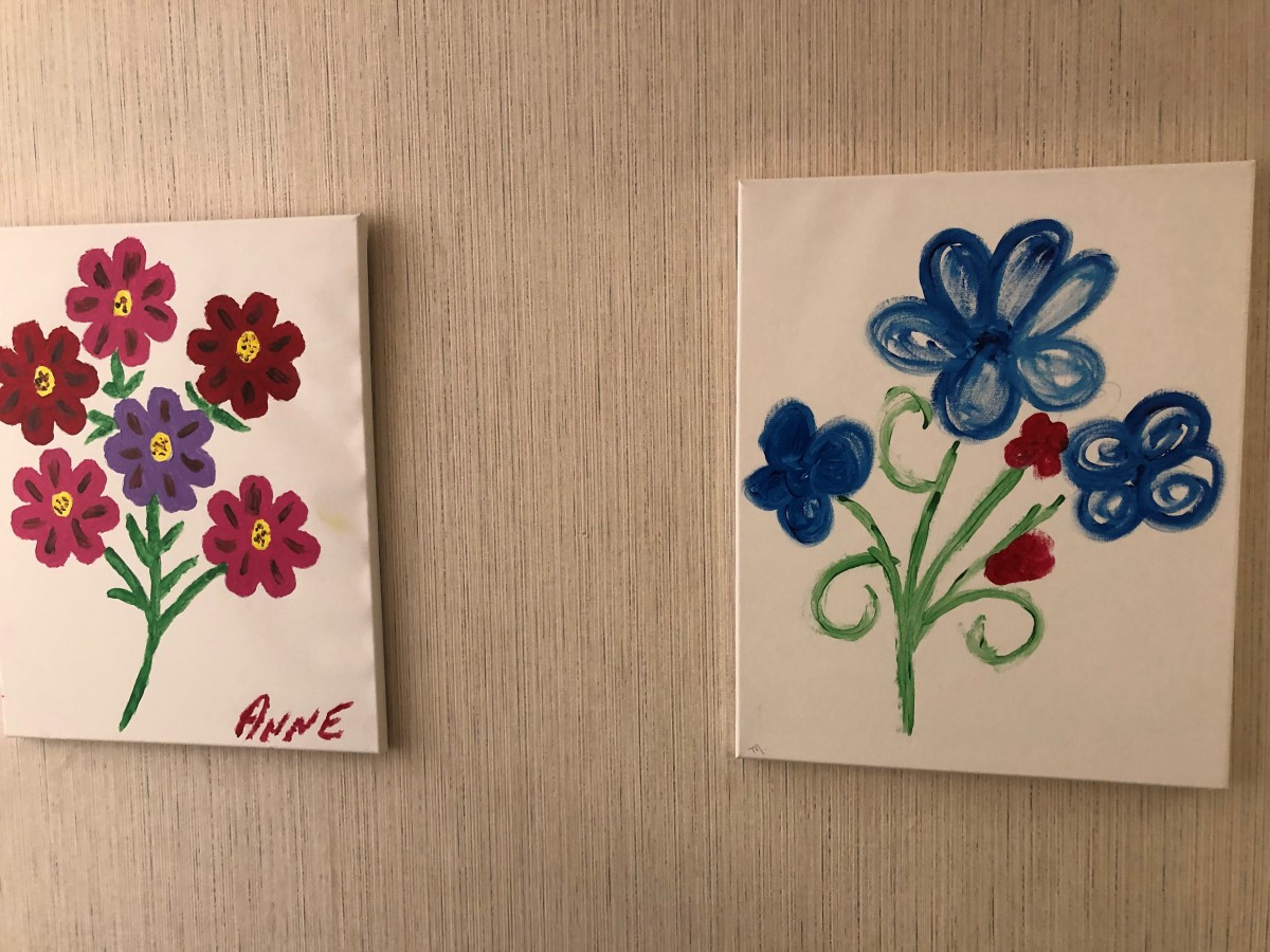 Two colorful floral paintings on a wall.