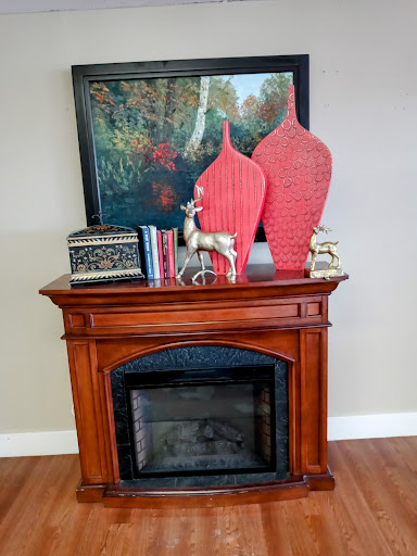 A stylish living room display featuring a decorative fireplace, vibrant vases, and an artistic touch.
