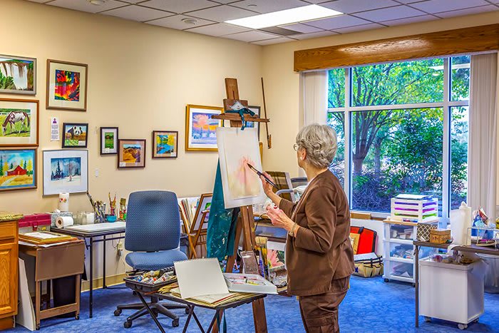 An artist working on a canvas in a cozy art studio.