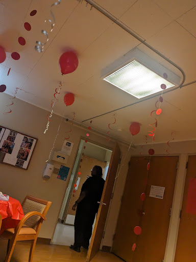 A decorated hospital room with pink decorations hanging from the ceiling, creating a festive atmosphere.