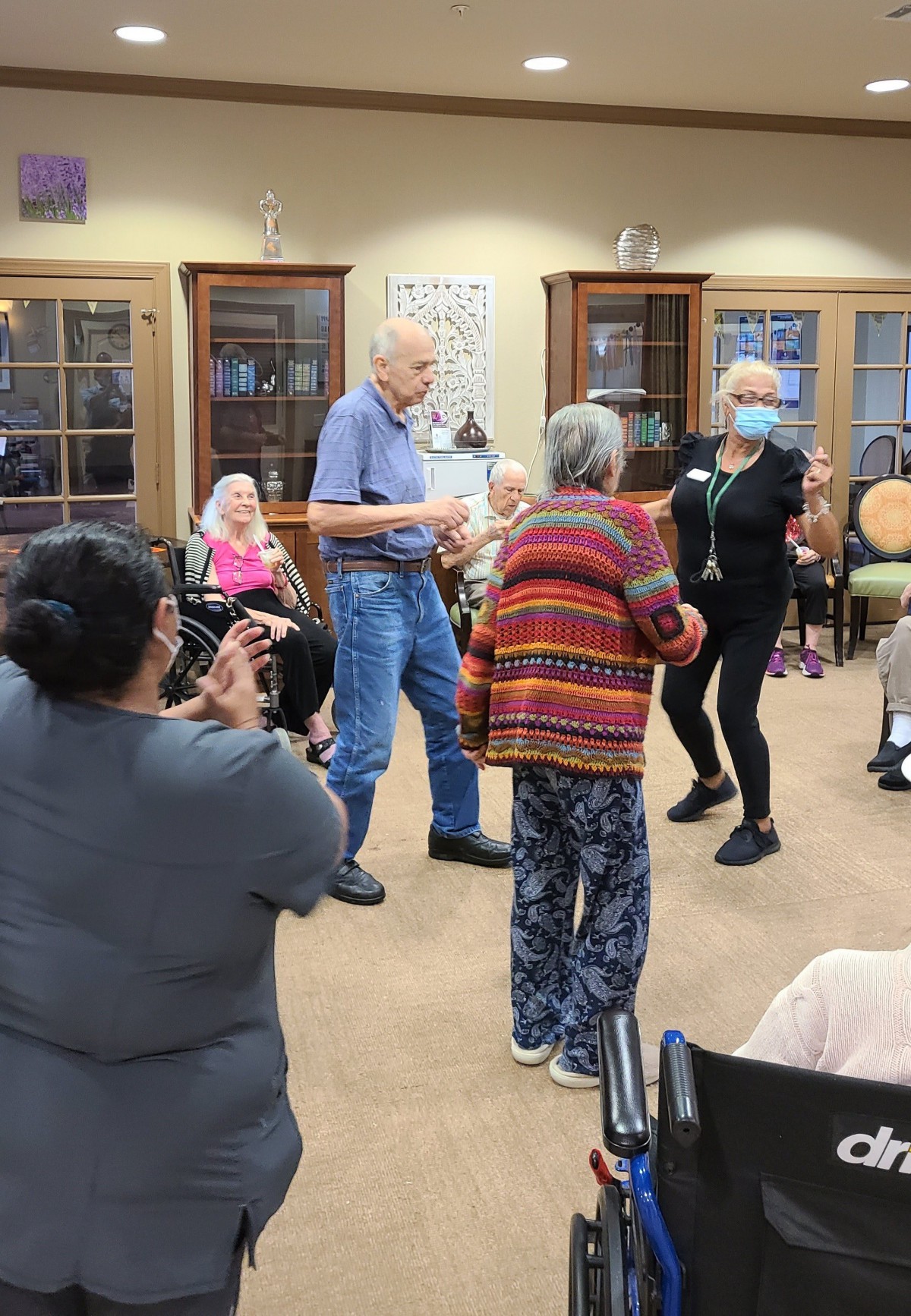 Residents and staff enjoy a dance activity at a nursing home.