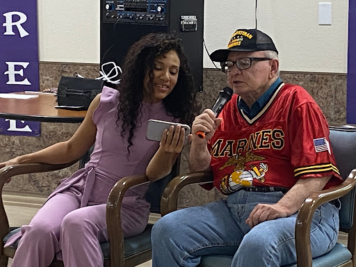 A young woman and an elderly man share a joyful moment during a performance, engaging with each other while enjoying music.