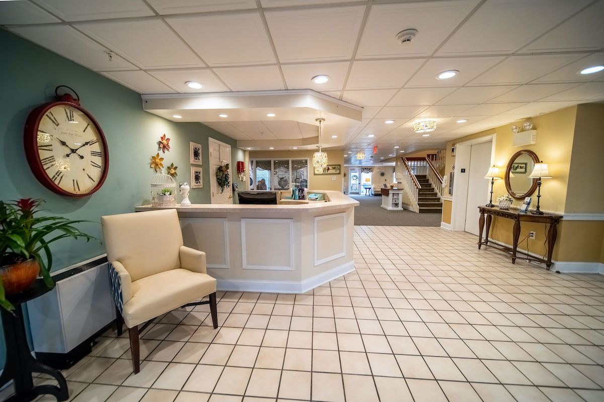 A welcoming reception area with a desk, comfortable chair, and tiled flooring.