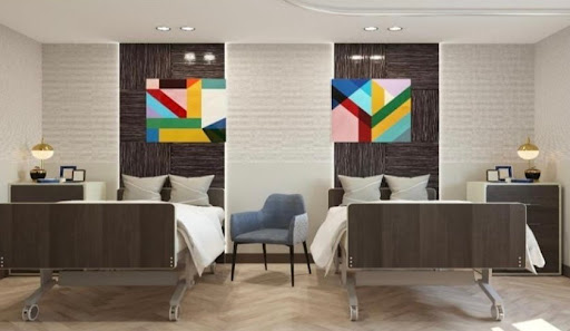 A modern hotel room featuring twin beds and vibrant abstract art on the walls.