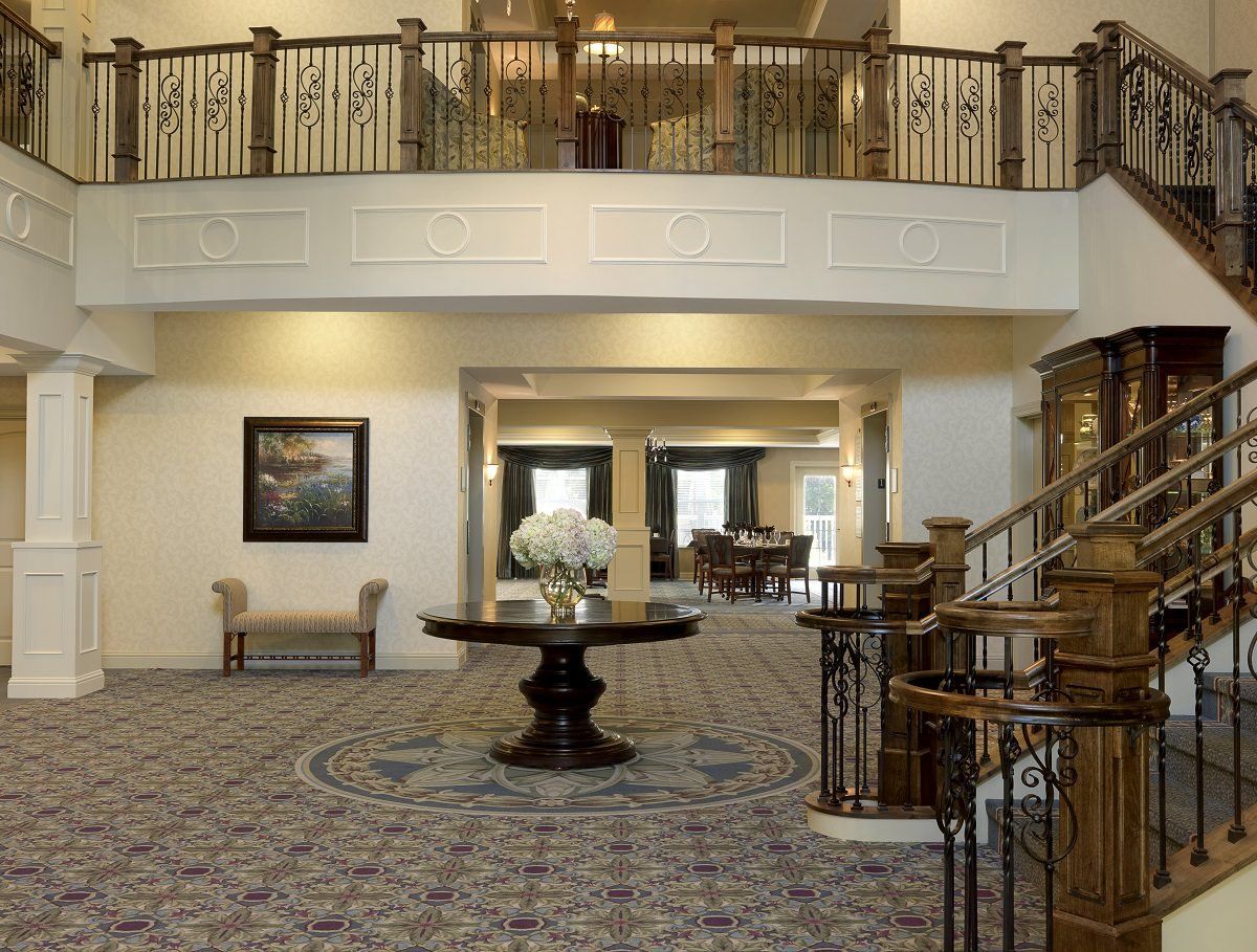 A spacious lobby with elegant decor and a grand staircase.