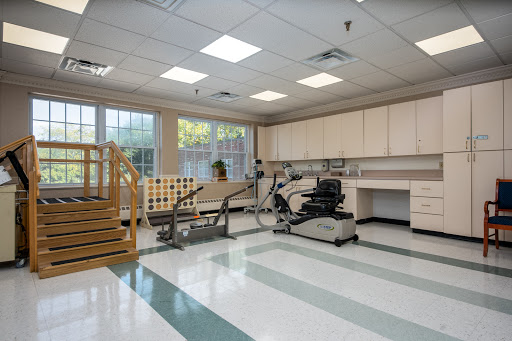 A spacious physical therapy room equipped with exercise equipment and a set of stairs for rehabilitation training.