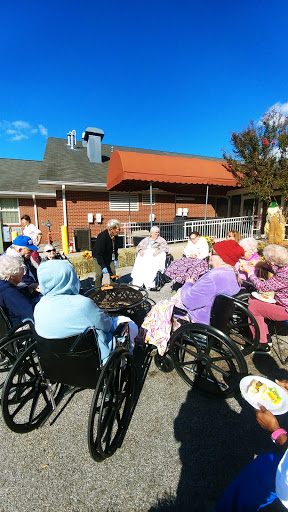 Elderly residents enjoying a sunny day outdoors at a care facility.