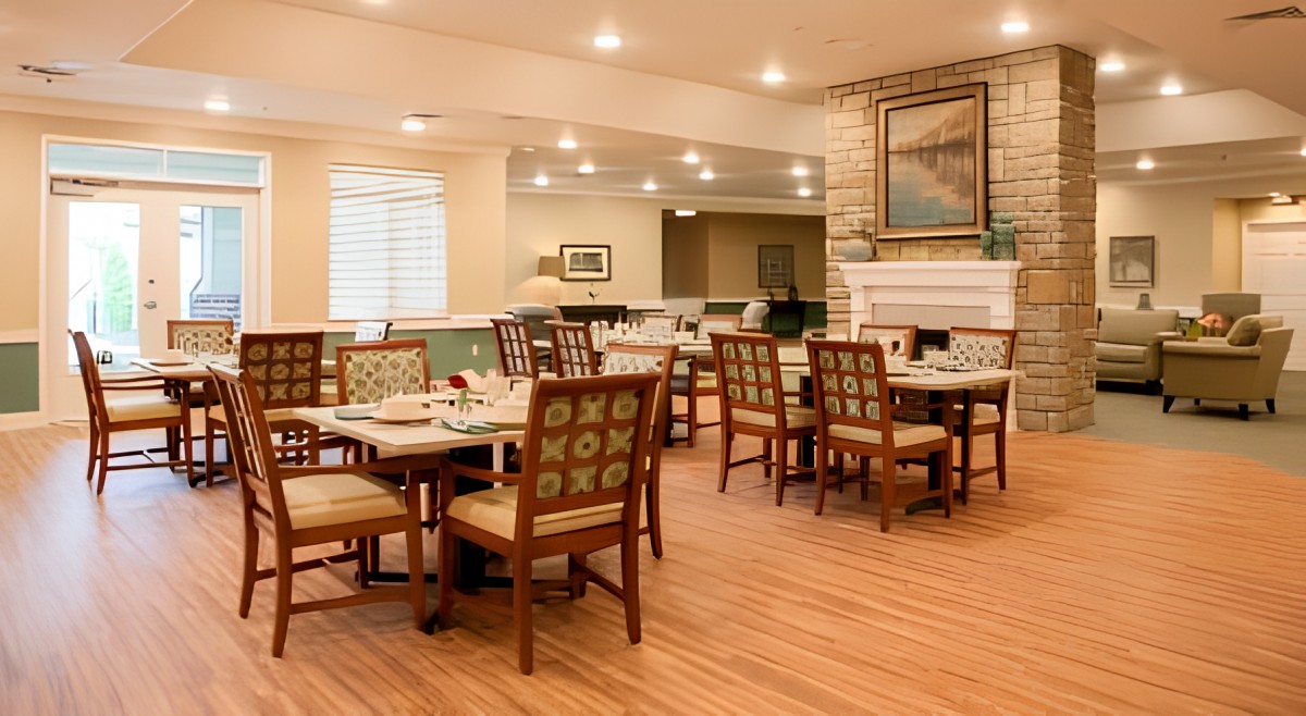 A cozy and well-lit dining room with neatly arranged tables and chairs.