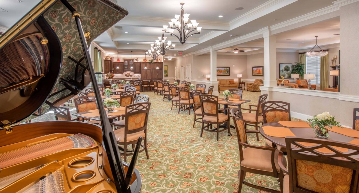 A spacious dining area with elegant furnishings and chandeliers.