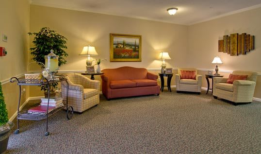 A cozy living room with a sofa, chairs, and warm lighting.