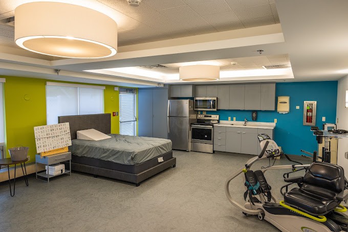 A modern interior featuring a bedroom with a kitchenette and contemporary furniture.