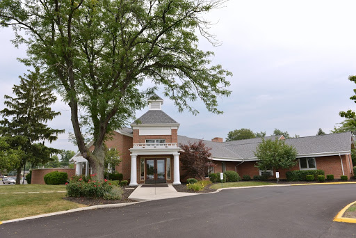 A welcoming entrance to a facility surrounded by greenery.