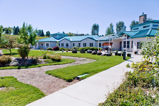 A serene view of a modern building surrounded by green lawns and walkways.