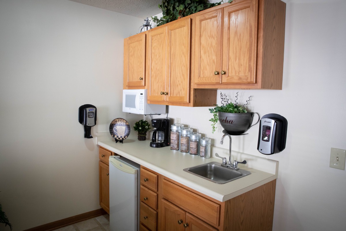 A small office kitchen setup with a coffee maker, microwave, and countertop appliances.