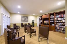 A conference room with organized seating and a large bookshelf.