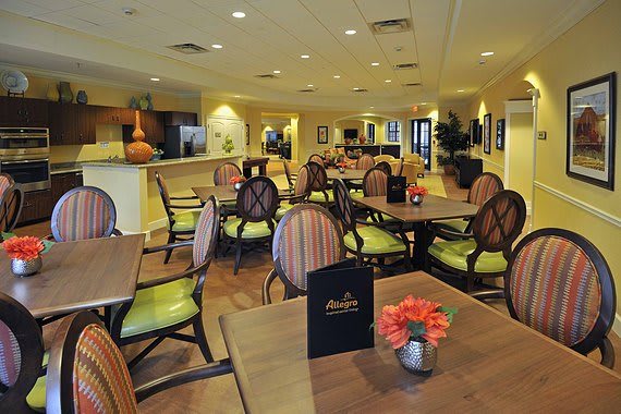 A cozy restaurant dining area with tables and chairs, featuring menus on the tables and warm decor.