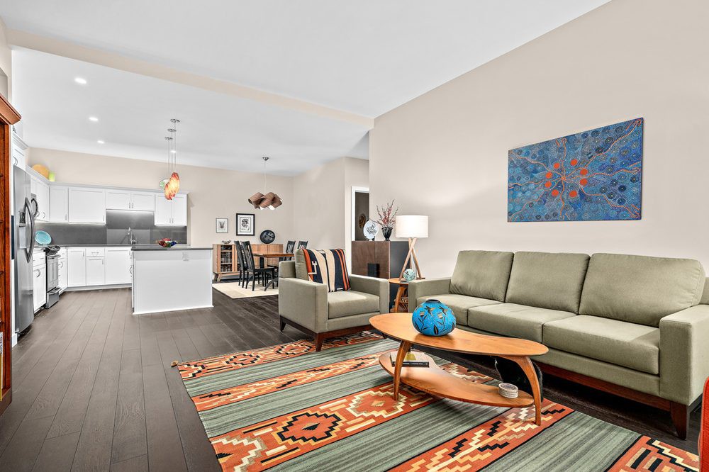 A modern open-plan living room with a stylish kitchen, dining area, and contemporary decor.