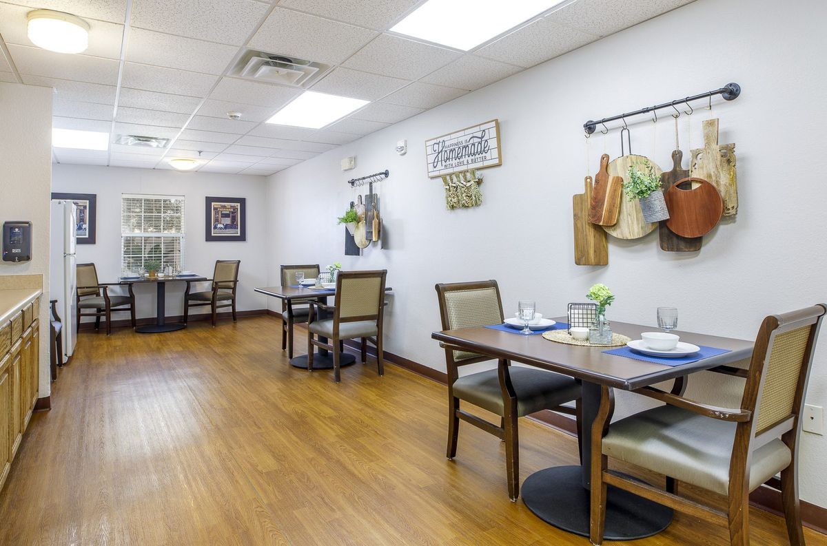 A cozy dining area with neatly arranged tables and decorative wall items.