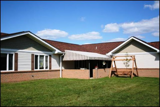 A charming residential home with a covered patio and a swing in the backyard.