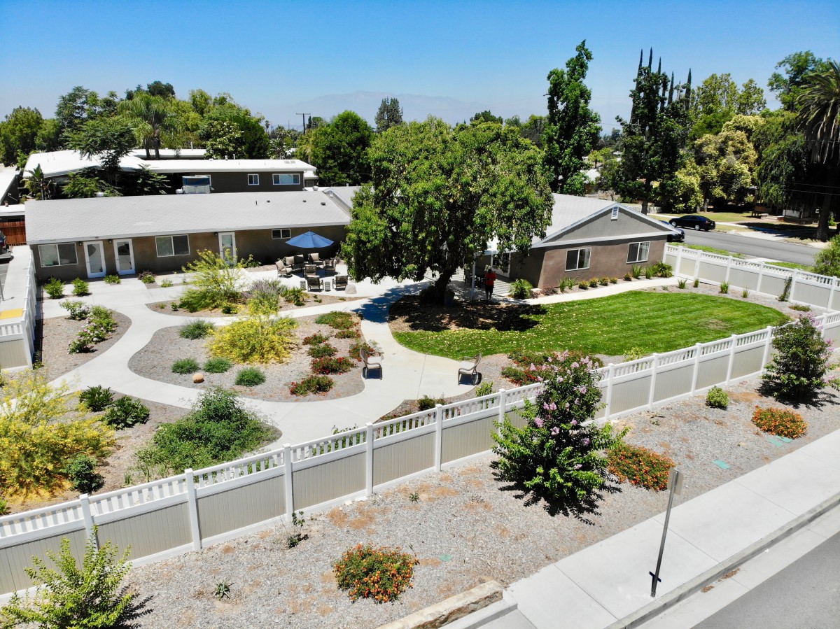 Aerial view of a well-maintained house with a landscaped yard and garden.