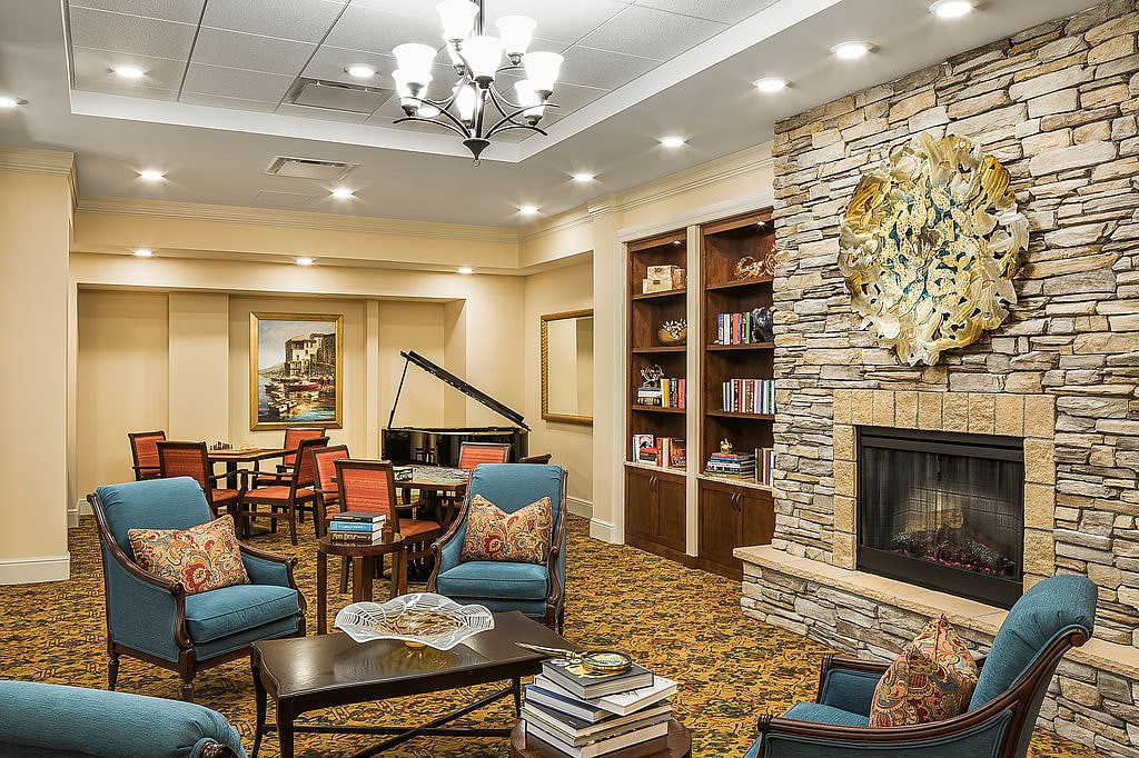 A cozy living room with a fireplace, bookshelves, and a seating area.