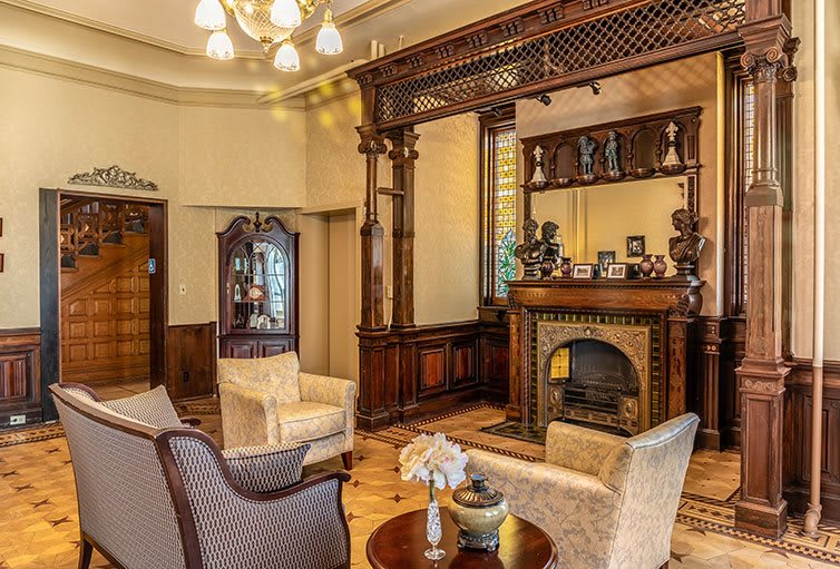 A cozy vintage living room with classic wooden decor and a fireplace.