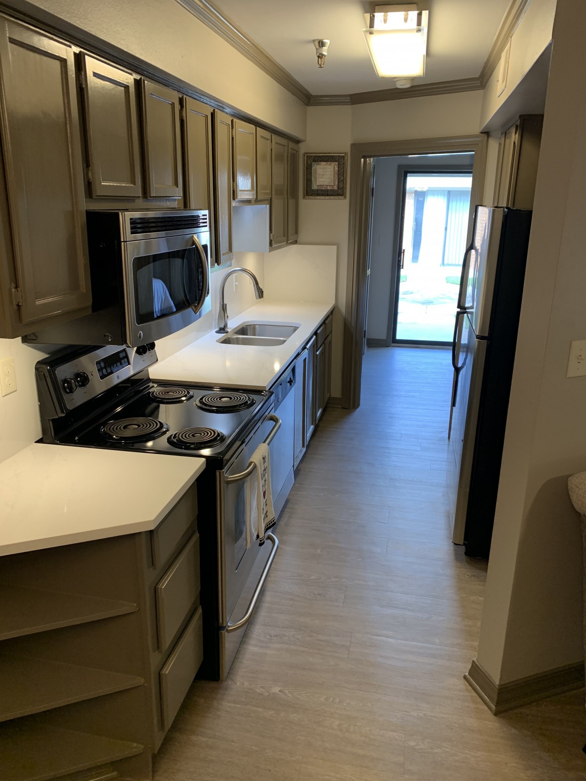 A modern galley kitchen with stainless steel appliances and ample cabinetry.