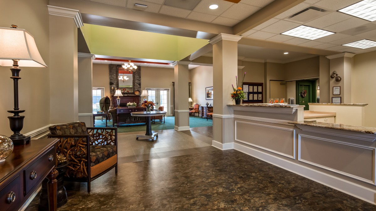 A spacious and well-lit lobby area featuring comfortable seating and a reception desk.