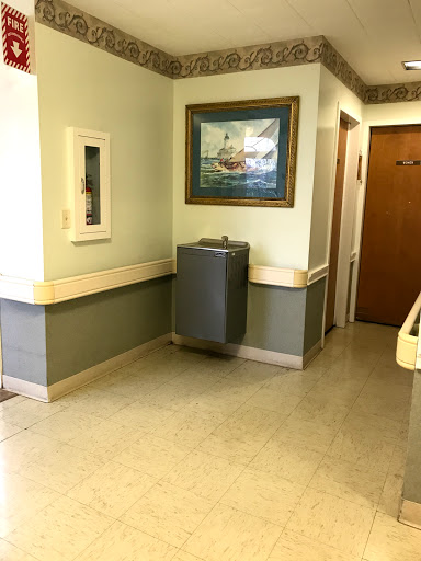 A quiet hallway featuring a water cooler and a framed artwork.