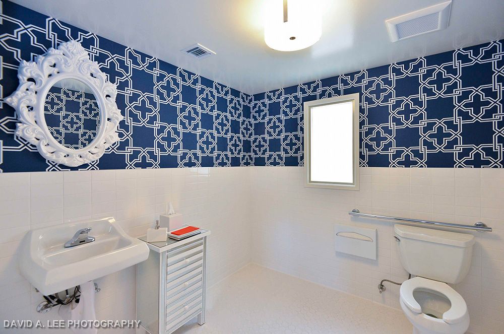 A stylish bathroom with blue patterned wallpaper and modern fixtures.