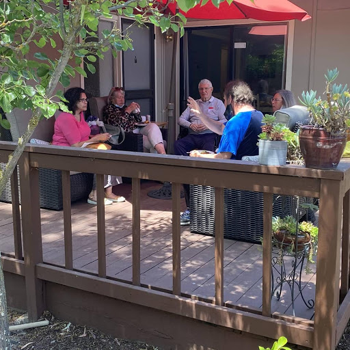 A group of friends enjoying a relaxing afternoon on the patio, engaging in lively conversation under the sun.
