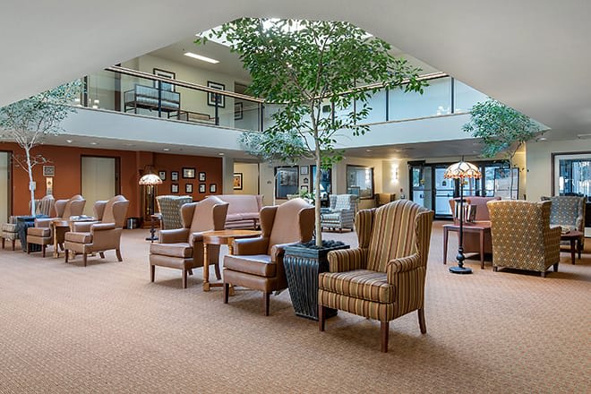 A spacious lounge area with comfortable seating and indoor plants.