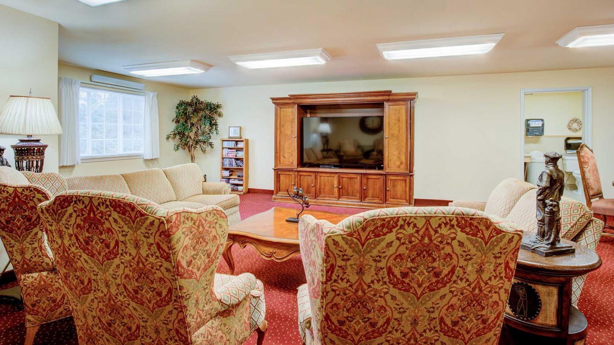 A cozy living room with comfortable seating and a large television in a wooden cabinet.