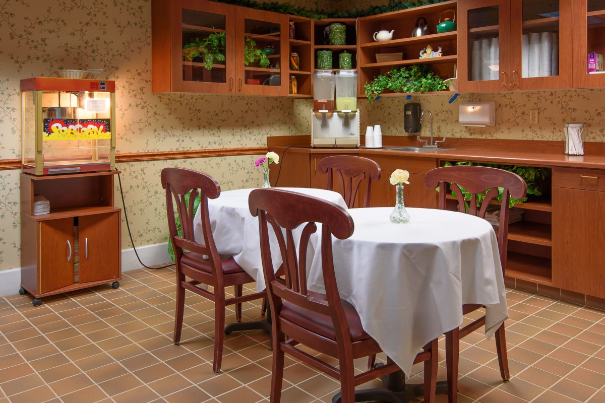 A cozy kitchen and dining area with wooden furniture and decorative plants.