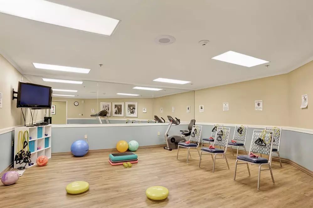 A spacious exercise room with yoga balls and stationary bikes.