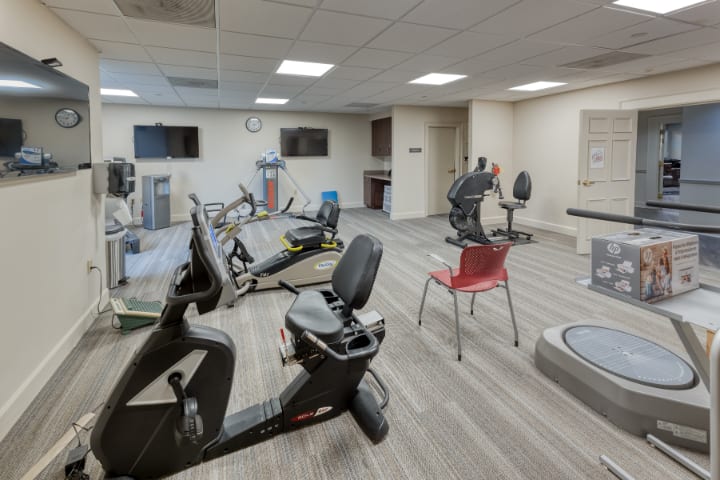 A well-equipped gym with various exercise machines and a spacious interior.
