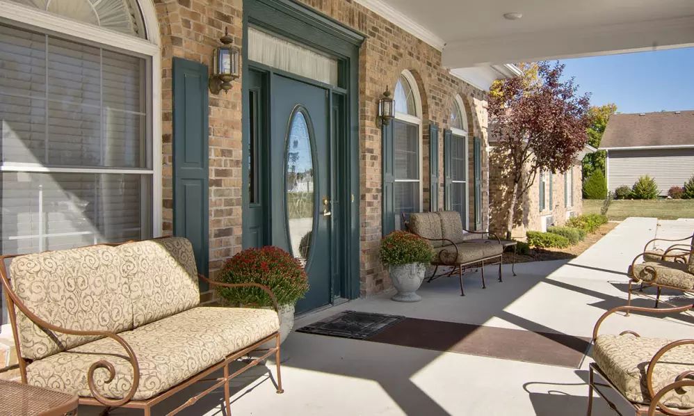 A welcoming front porch with seating and greenery.