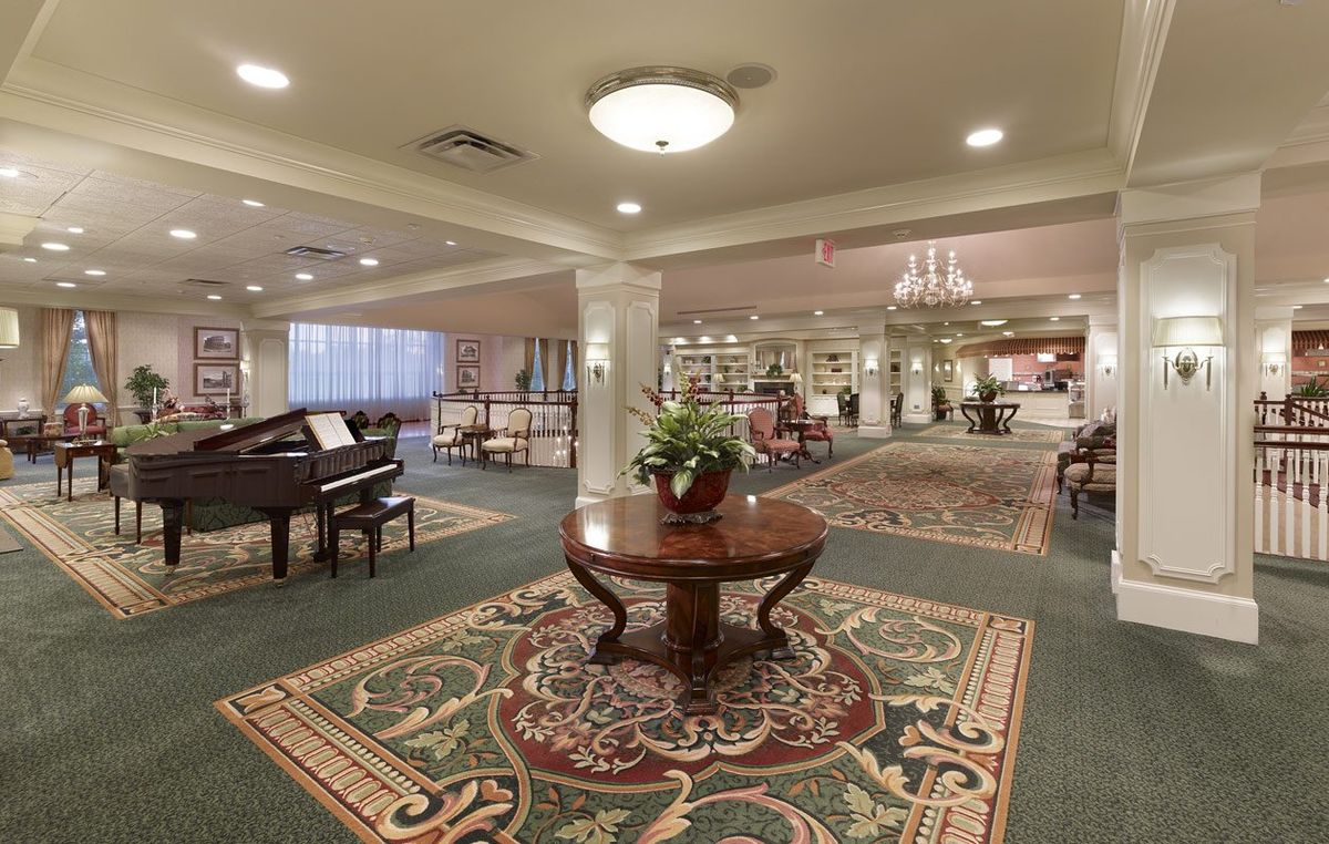 A spacious, elegantly decorated lobby featuring a grand piano and luxurious furnishings.