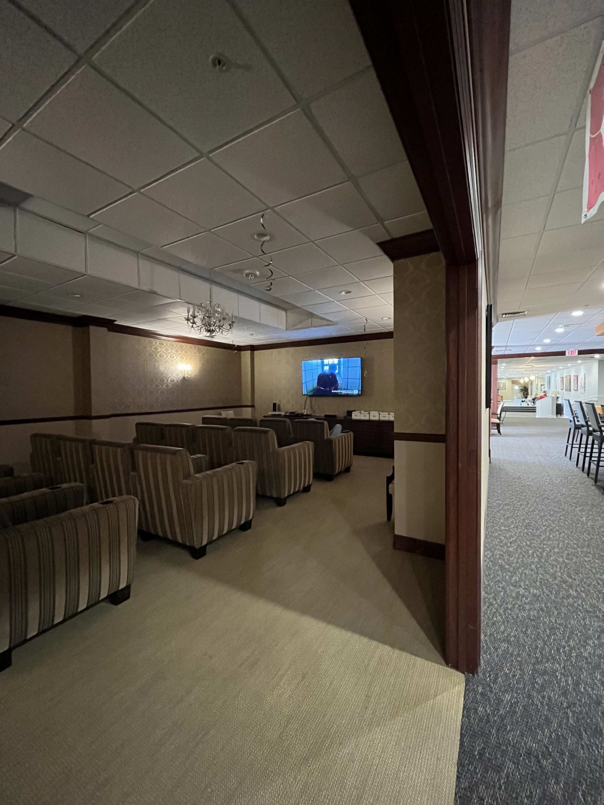 A lounge area with armchairs facing a television screen, ideal for meetings or relaxation.