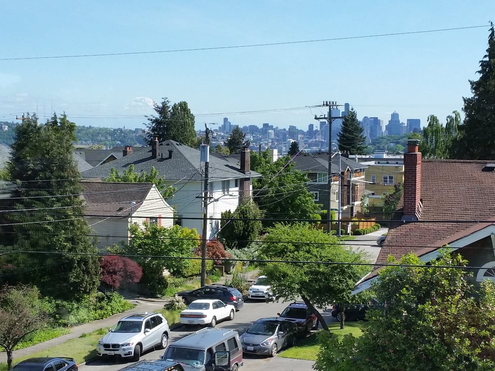 A view of a residential neighborhood with a city skyline in the background.