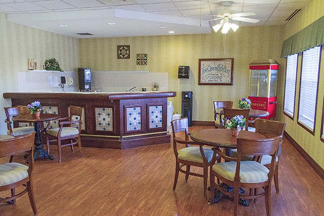 A cozy cafe interior featuring a wooden bar counter, seating area, and stylish decor.