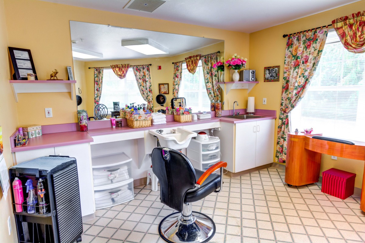 A cozy hair salon interior featuring a styling chair, large mirror, and colorful decor.