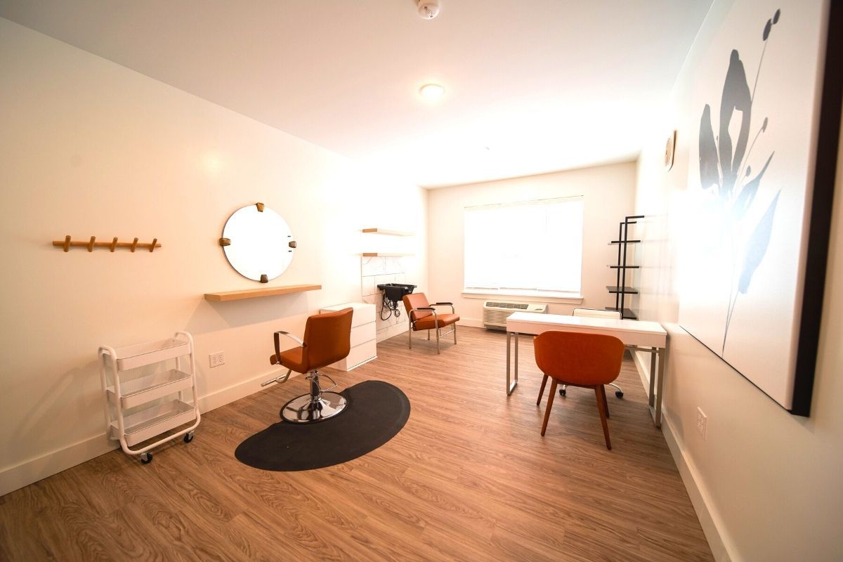 A well-lit, modern beauty salon with minimalist furnishings and a makeup station.