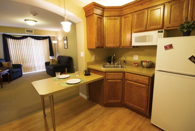 A cozy kitchen with wooden cabinets and a small dining area.